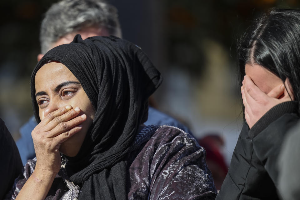 Women observe a minute of silence for a church sacristan who was killed Wednesday in Algeciras, southern Spain, Thursday, Jan. 26, 2023. Residents of the Spanish city of Algeciras recounted their shock after a machete-wielding attacker jumped on the altar of a church before chasing a victim into a city square and inflicting mortal wounds. The attacks on two churches by a single assailant on Wednesday night have shaken the city near the southern tip of Spain across from a bay from Gibraltar. (AP Photo/Juan Carlos Toro)