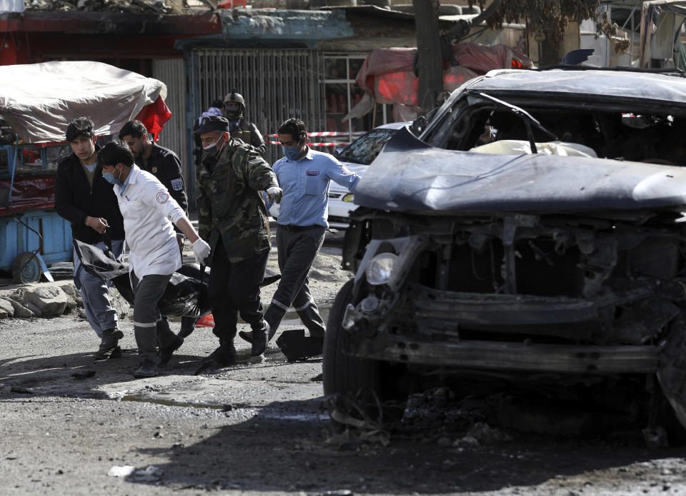 Security personnel and health workers carry a body from a bomb attack in Kabul, Afghanistan, Wednesday, Feb. 10, 2021. (AP Photo/Rahmat Gul)