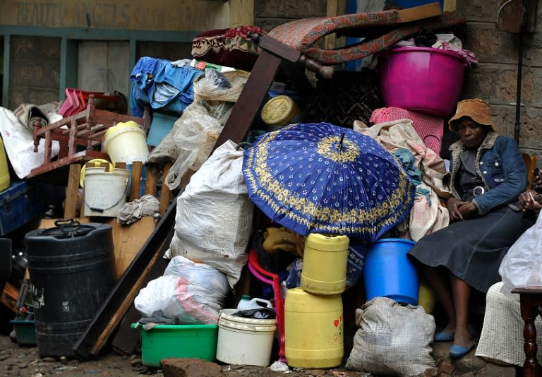 A woman sits next to her belongings after a building collapsed in Nairobi on April 30, 2016