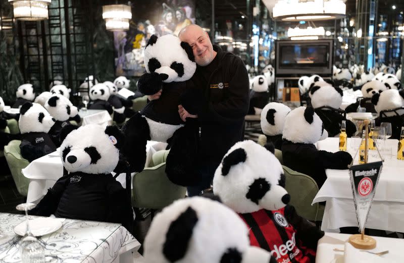 El propietario de un restaurante italiano Giuseppe "Pino" Fichera sostiene un oso panda de juguete como parte de la instalación de arte "Panda mie" en su restaurante para crear conciencia sobre el impacto comercial del cierre del COVID-19 en la gastronomía en Fráncfort, Alemania