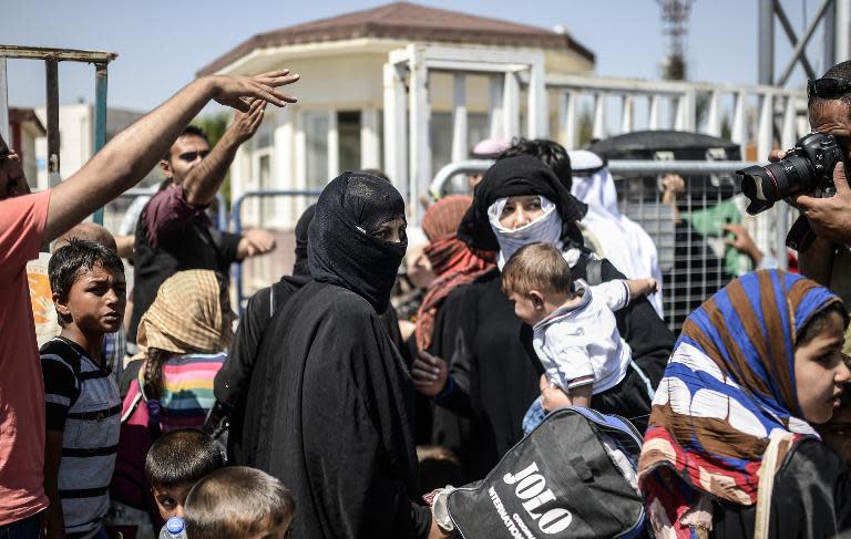 Syrian refugees wait at the Akcakale border crossing in Turkey before returning to northern Syrian town of Tal Abyad, on June 17, 2015