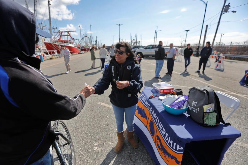 Deb Kelsey of Fishing Partnership Support Services, hands out some disinfecting spray to a fisherman during a free health and wellness event hosted by the Greater New Bedford Waterfront Task Force on Leonard's Wharf in New Bedford.
(Photo: PETER PEREIRA/The Standard-Times)