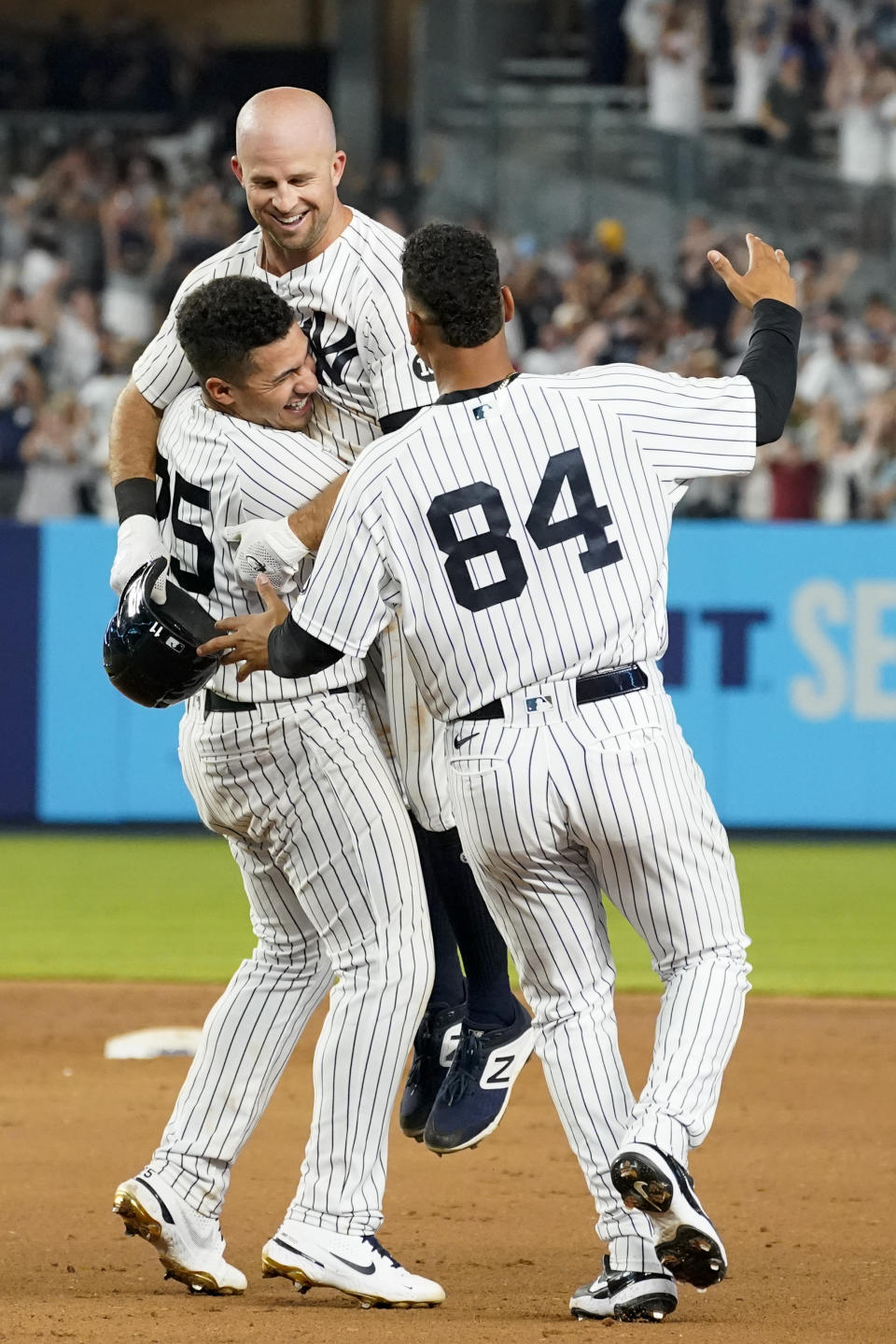 New York Yankees' Brett Gardner, center, celebrates his walkoff winning RBI-single with Albert Abreu (84) and Gleyber Torres (25) in the11th inning of a baseball game against the Seattle Mariners, Friday, Aug. 6, 2021, in New York. (AP Photo/Mary Altaffer)