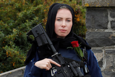 A policewoman is seen as people attend the burial ceremony of a victim of the mosque attacks, at the Memorial Park Cemetery in Christchurch, New Zealand March 21, 2019. REUTERS/Jorge Silva