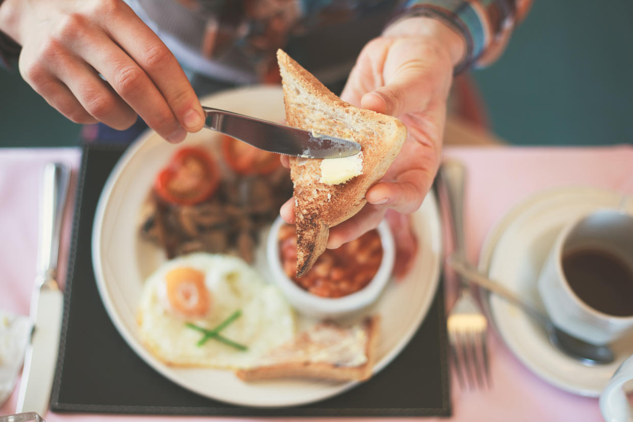 Closeup on a young woman's hands as she is having breakfast