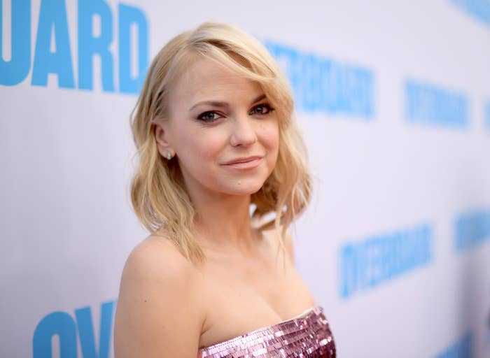 Faris wears a strapless dress while looking in the camera at a red carpet event