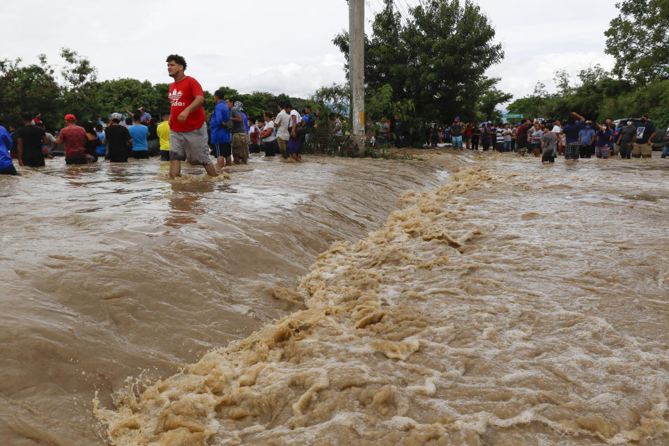 Residents wait to be rescued from a flooded area near Lima, Honduras, Thursday, Nov. 5, 2020. The storm that hit Nicaragua as a Category 4 hurricane on Tuesday had become more of a vast tropical rainstorm, but it was advancing so slowly and dumping so much rain that much of Central America remained on high alert. (AP Photo/Delmer Martinez)