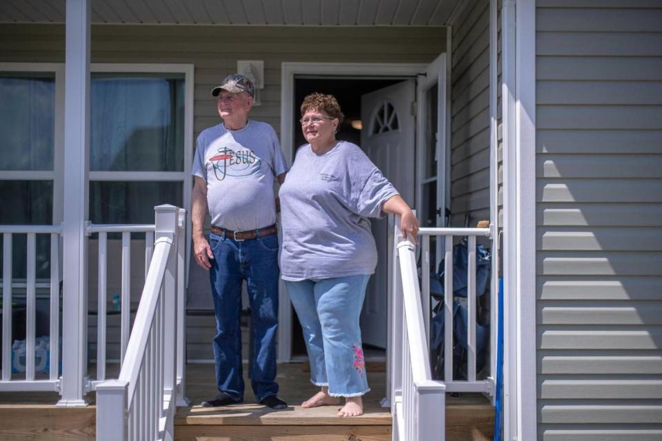 Sherry and George Mullins poses for a portrait in front of their new home in Perry County, Ky., on Tuesday, July 11, 2023. They bought the home from the Hazard-based Housing Development Alliance after their former home was destroyed in last summer’s flooding.