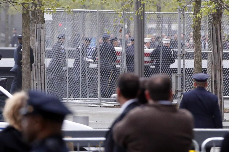 Officials acting as pallbearers carry a casket with the unidentified remains of victims of the Sept. 11, 2001 attacks as they are returned to the World Trade Center site, Saturday, May 10, 2014, in New York. The remains were moved from the Office of the Chief Medical Examiner on Manhattan's East Side at dawn Saturday to an underground repository in the same building as the National September 11 Memorial Museum. (AP Photo/Julio Cortez)