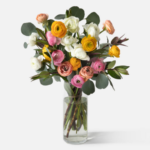 floral arrangement inside a clear vase against white background