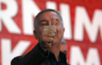 FILE - In this Monday, Oct. 17, 2016 file photo, long-ruling Democratic Party of Socialists leader Milo Djukanovic, gives a thumbs up in his headquarter, in Podgorica, Montenegro. Montenegro's President Milo Djukanovic says the upcoming parliamentary vote is crucial in the defense of the small Balkan country's independence in the face of renewed attempts from Serbia and Russia to install their nationalist and anti-Western allies to power. (AP Photo/Darko Vojinovic, File)