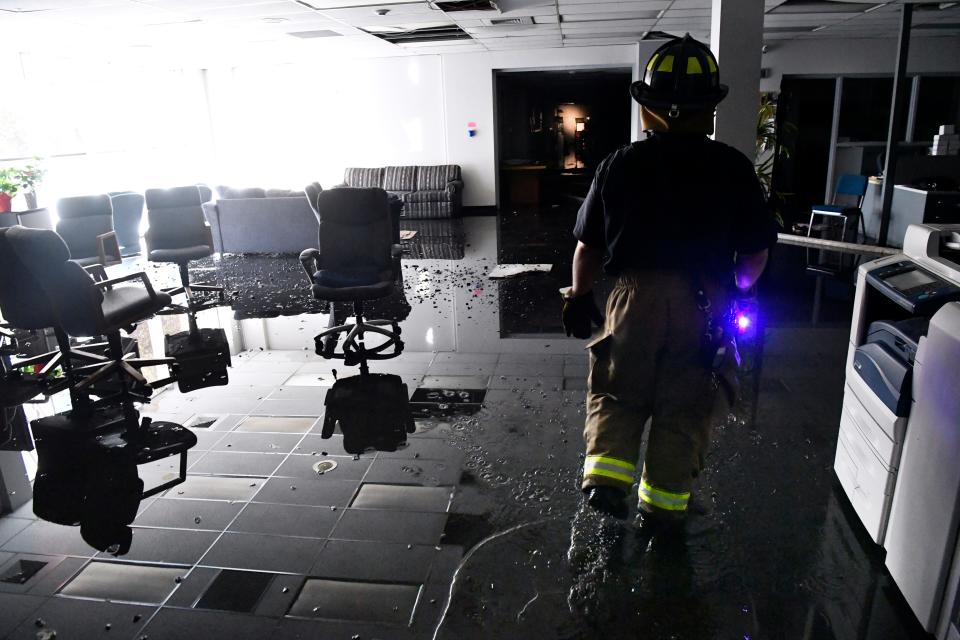 An Abilene firefighter escorts Ron Erdrich through the Abilene Reporter-News to retrieve hard drives and other items from the newsroom. The fire department responded to a two-alarm blaze at the newspaper Nov. 15, 2018.