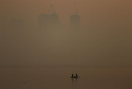 FILE PHOTO: Men row a boat in the waters of the Arabian Sea on a smoggy evening in Mumbai, India, January 18, 2019. REUTERS/Francis Mascarenhas/File Photo