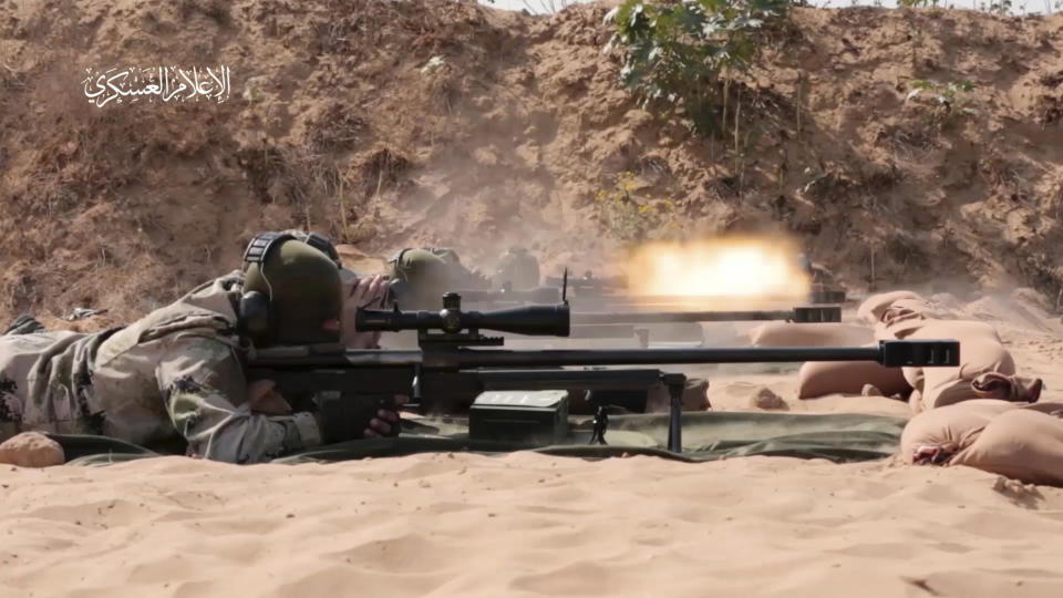 This image from video posted by Hamas on Dec. 20, 2023, purports to show Hamas militants using domestic copies of the AM-50 Sayyad, an Iranian-made a sniper rifle that fires a .50- caliber round powerful enough to punch through up to an inch of steel. Experts interviewed by The Associated Press said it would be nearly impossible for Hamas to manufacture a safe and accurate sniper rifle using the rudimentary equipment shown in the video. Watermark at upper left reads “military media.” (Hamas via AP)