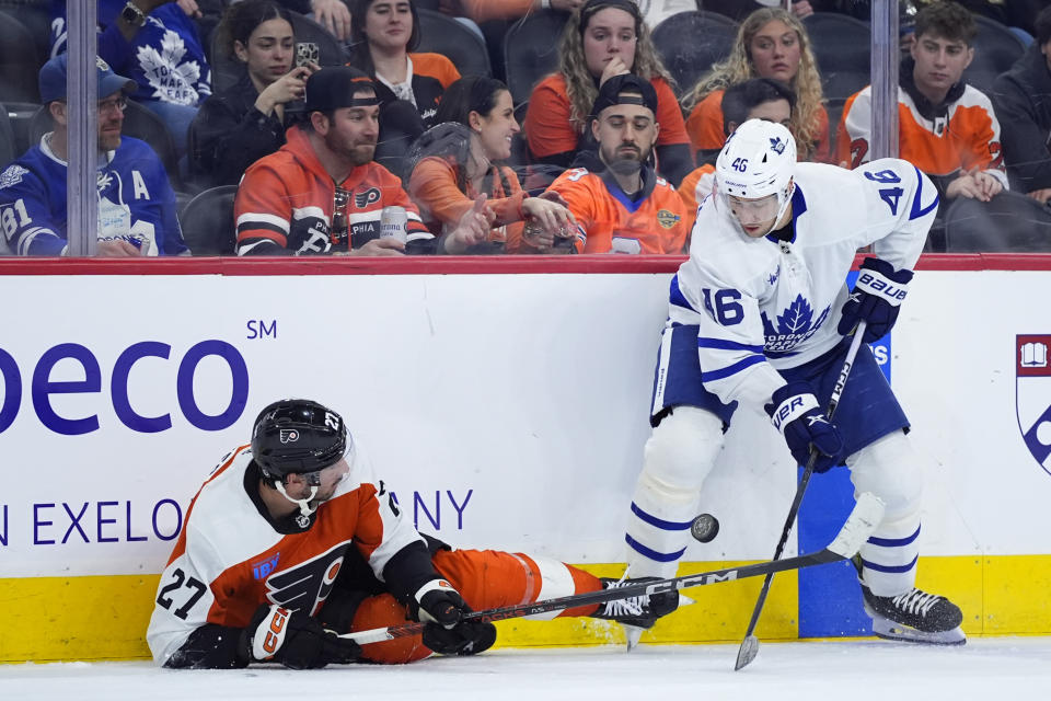 Philadelphia Flyers' Noah Cates, left, and Toronto Maple Leafs' Ilya Lyubushkin battle for the puck during the third period of an NHL hockey game, Thursday, March 14, 2024, in Philadelphia. (AP Photo/Matt Slocum)