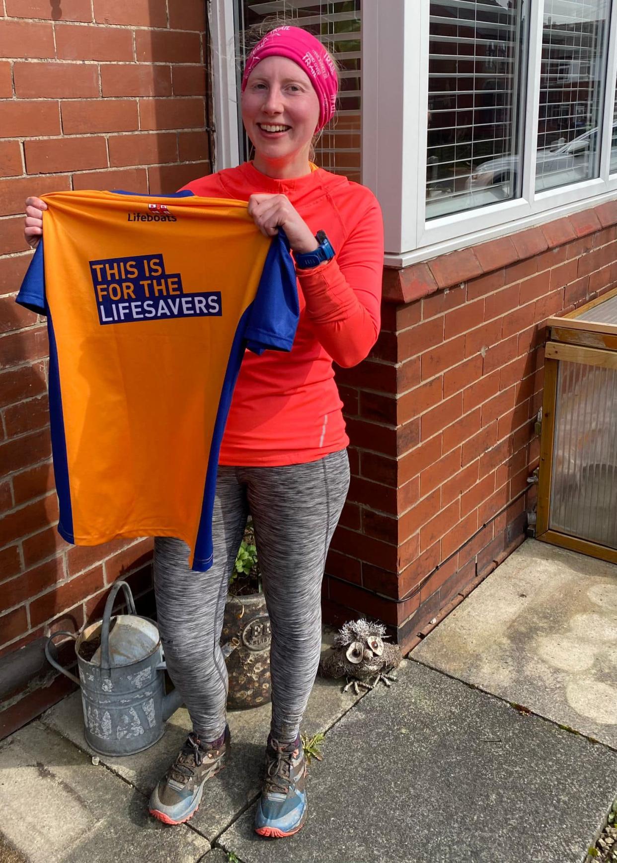 Ms Houghton shows off a t-shirt made ahead of a 10k race to raise money for the RNLI. (RNLI/PA)