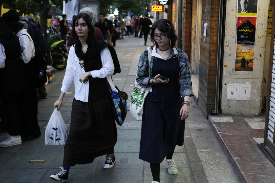 Two Iranian women without wearing their mandatory Islamic headscarf walk in downtown Tehran, Iran, Monday, June 10, 2024. (AP Photo/Vahid Salemi)