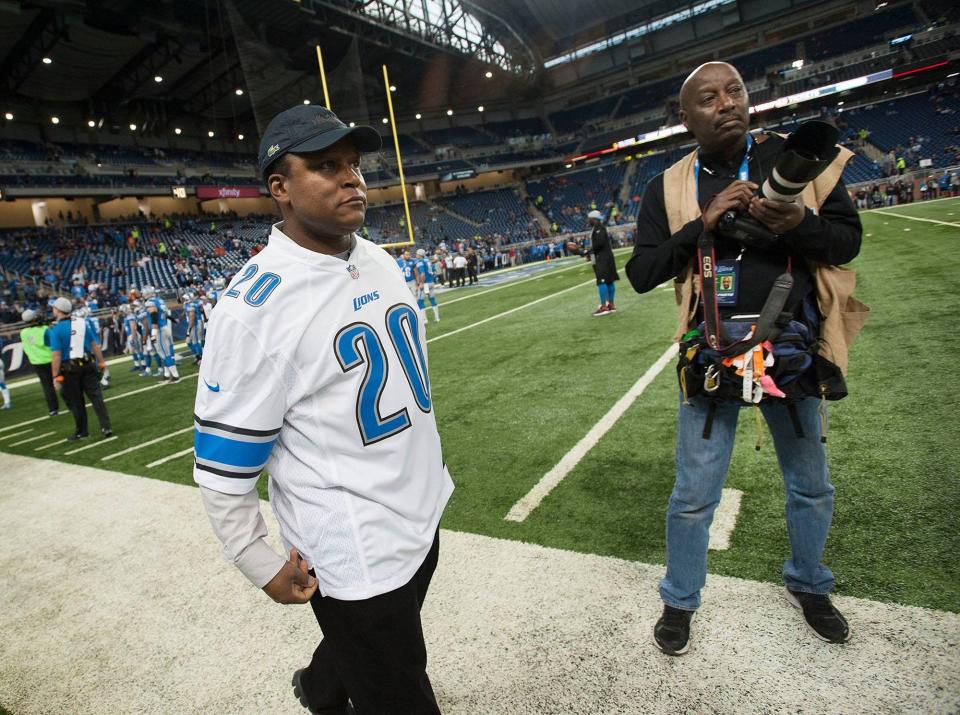 Two legends in one photo as Detroit Free Press photographer Kirthmon F. Dozier, right stands on the sidelines of Ford Field as Lions great Barry Sanders walks by.