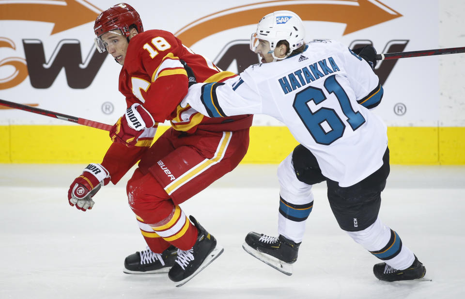 San Jose Sharks' Santeri Hatakka, right, grabs for Calgary Flames' Tyler Pitlick during the first period of an NHL hockey game, Tuesday, Nov. 9, 2021 in Calgary, Alberta. (Jeff McIntosh/The Canadian Press via AP)