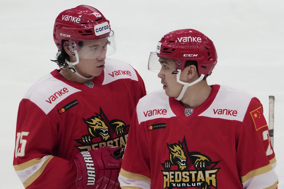 Kunlun Red Star's Spencer Foo, left, and Jason Fram talk during the Kontinental Hockey League ice hockey match between Kunlun Red Star Beijing and Avangard Omsk in Mytishchi, outside Moscow, Russia, Wednesday, Nov. 17, 2021. (AP Photo/Pavel Golovkin)