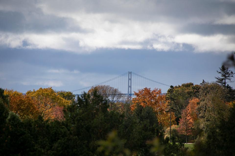 Fall colors explode from Mackinac Island with a view of the Mackinac Bridge in the background.