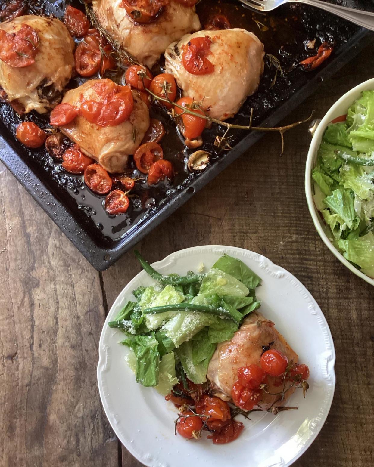 <span>Rachel Roddy’s baked chicken thighs with tomatoes, and a green bean, lettuce and parmesan salad.</span><span>Photograph: Rachel Roddy/The Guardian</span>