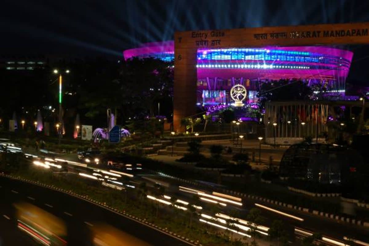 Vehicles drive along a street in front of the 27-feet tall bronze figurine statue 'Nataraja' installed at a G20 India summit venue in New Delhi (AFP via Getty Images)