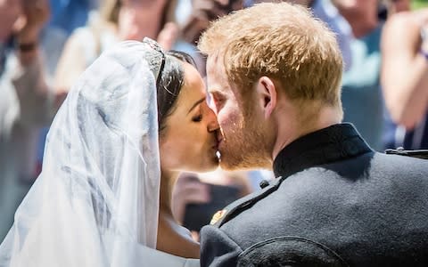 Meghan Markle and Prince Harry kiss on the steps of St George's Chapel at Windsor Castle - Credit: Danny Lawson