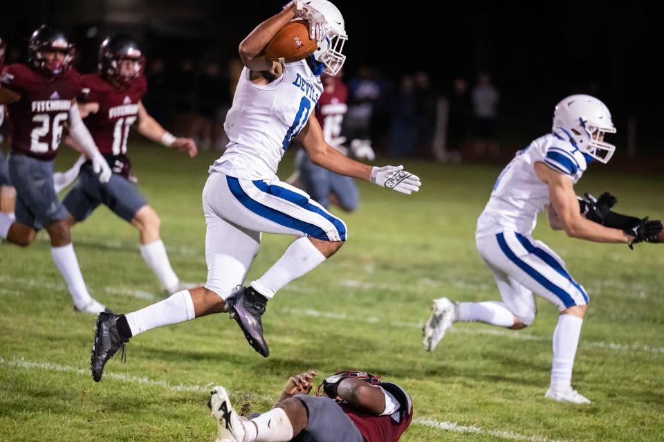 Leominster's Ricky Encarnacion hops over Fitchburg's Joshua Nartey.