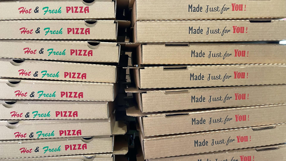 Stack of pizza boxes with "Hot & Fresh PIZZA Made Just for You!" written on them