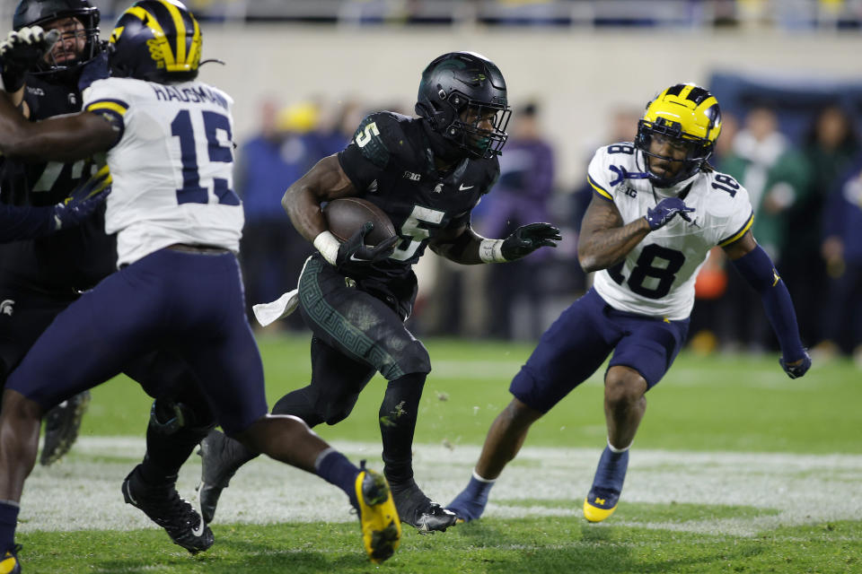 Michigan State running back Nathan Carter (5) runs against Michigan defensive back Ja'Den McBurrows (18) during the second half of an NCAA college football game, Saturday, Oct. 21, 2023, in East Lansing, Mich. (AP Photo/Al Goldis)