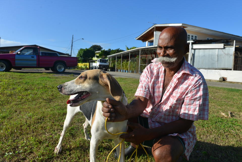 In this Dec. 31, 2013 photo, 64-year-old hunter Francis Guelmo poses for a photo with one of his hunting hounds on the outskirts of Chaguanas, Trinidad. The twin-island country of Trinidad and Tobago, at least on paper, has transformed the southernmost island nation of the Caribbean into a no-trapping, no-hunting zone for about two years to give overexploited game animals some breathing room and to conduct wildlife surveys. Some 13,000 licensed hunters and their trained hounds are now forbidden to hunt on state lands. Hunters allege that police are often the biggest poachers, with some stations regularly hosting end-of-the-week cookouts with freshly caught howler monkey or wild hog. (AP Photo/David McFadden)