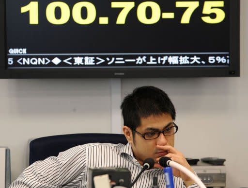 A money dealer works before an exchange rate board quoting 100.50-55 yen against the euro at a Tokyo foreign exchange market on June 18, 2012. Japan welcomed the result but called on Europe to "urgently" strengthen its financial sector and pressed Greece to swiftly form a new government