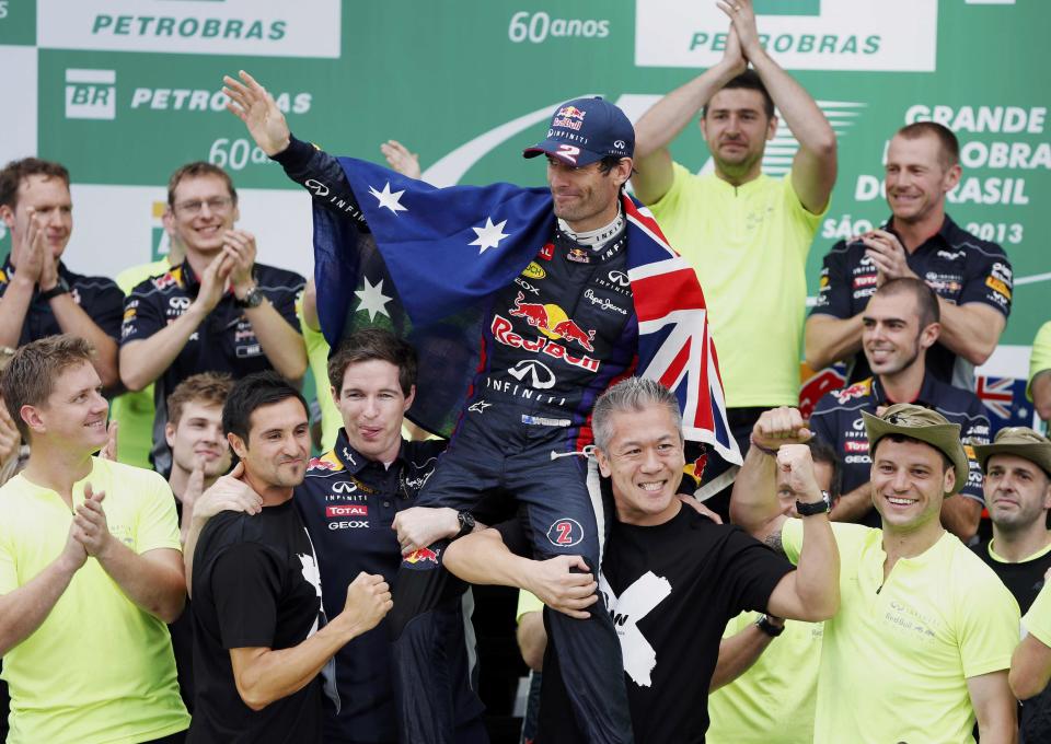 Mark Webber of Australia ackowledges the crowd as the Red Bull team celebrates their win in the F1 Grand Prix, after the Brazilian F1 Grand Prix at the Interlagos circuit in Sao Paulo