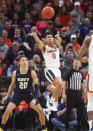 Virginia guard Kihei Clark (0) passes the ball next to Navy guard Greg Summers (20) during an NCAA college basketball game in Charlottesville, Va., Sunday, Dec. 29, 2019. (AP Photo/Andrew Shurtleff)