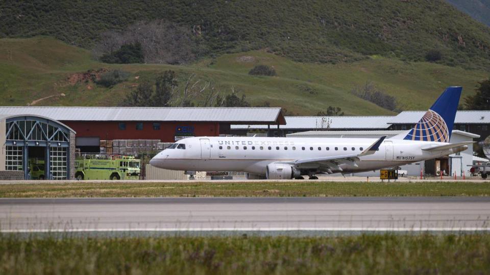 A United Express aircraft prepares to depart from San Luis Obispo County Regional Airport, with the fire engine and station in the background, on April 20, 2023.