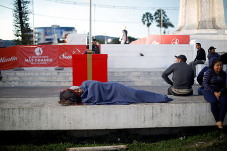 A man in a caravan of migrants departing from El Salvador en route to the United States sleeps at El Salvador del Mundo Square, in San Salvador, El Salvador, November 18, 2018. REUTERS/Jose Cabezas