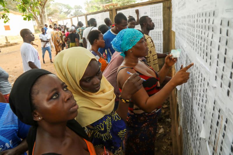 People check for their names at a polling station, during presidential election in Lome