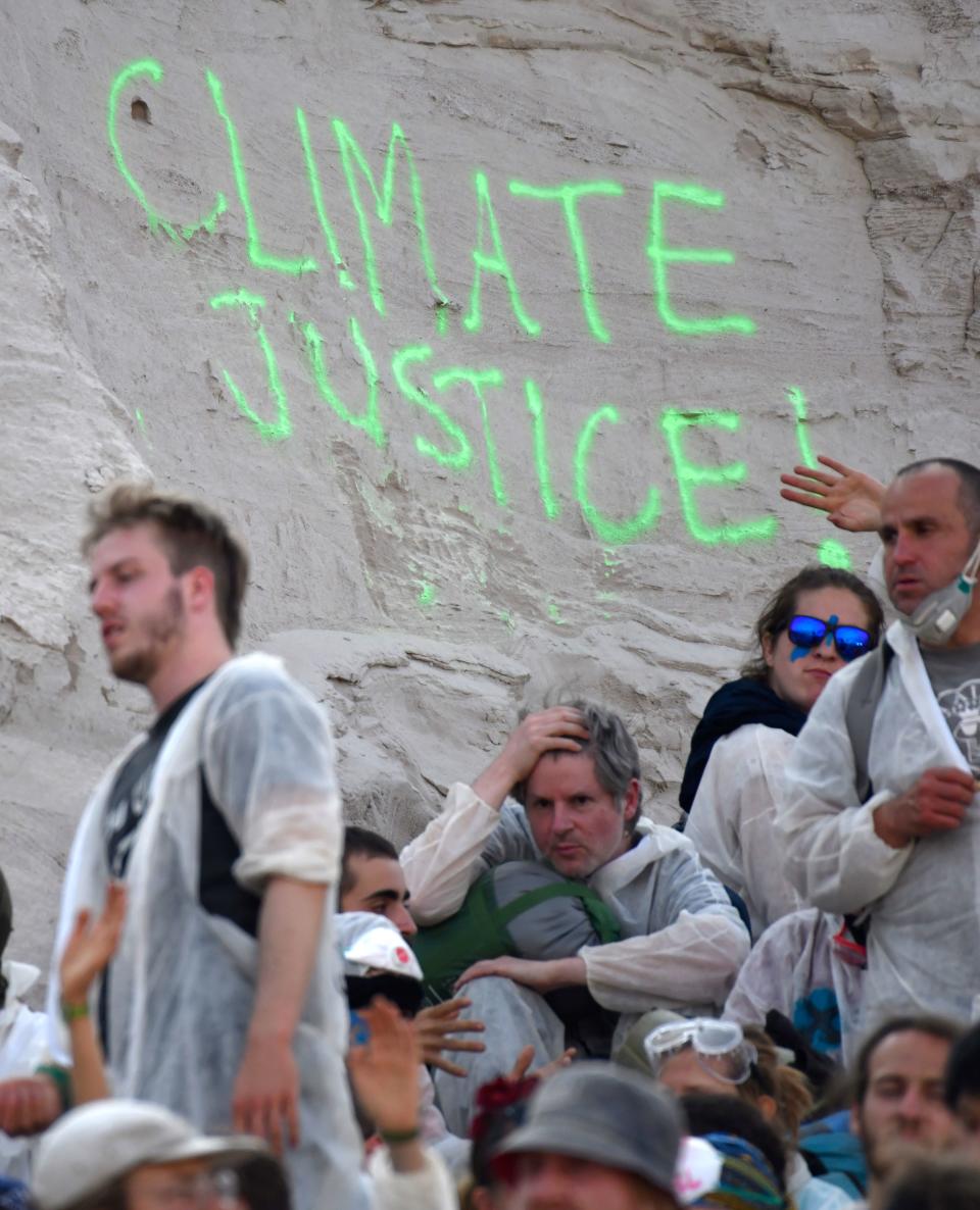 Climate activists sit on the ground after entering the Garzweiler brown coal mine in Garzweiler, western Germany, on June 22, 2019, during a weekend of massive protests in a growing "climate civil disobedience" movement. - Anti-coal activists try to occupy the Garzweiler open-cast lignite mine in a protest to demand action against global warming, now one of the hottest issues on the European political agenda. (Photo by INA FASSBENDER / AFP)        (Photo credit should read INA FASSBENDER/AFP/Getty Images)