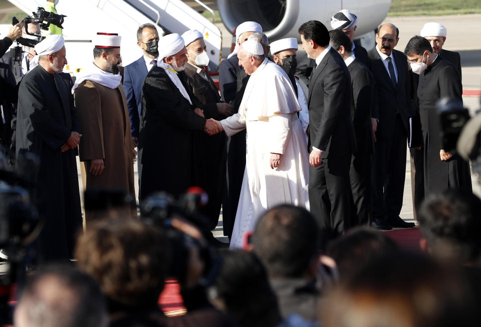 Muslim clerics welcome Pope Francis as he arrives in Irbil, Iraq, Sunday, March 7, 2021. Pope Francis arrived in northern Iraq on Sunday, where he planned to pray in the ruins of churches damaged or destroyed by Islamic State extremists and celebrate an open-air Mass on the last day of the first-ever papal visit to the country. (AP Photo/Hadi Mizban)