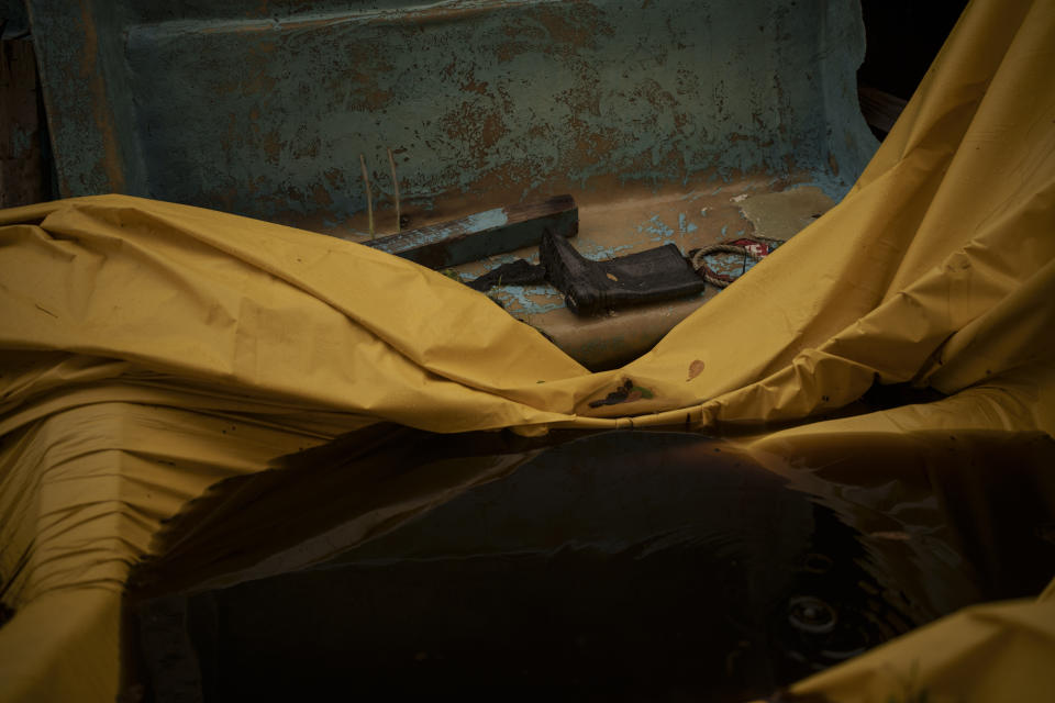 A boot is seen inside a Mauritanian boat that drifted to Tobago with 14 bodies and other skeletal remains, in Belle Garden, Trinidad and Tobago, Wednesday, Jan. 19, 2022. The boat was found by local fishermen drifting nearby on May 28, 2021 with 14 bodies and other skeletal remains inside. An AP investigation has found that the boat had departed the port town of Nouadhibou in Mauritania, Africa more than four months earlier with 43 migrants. (AP Photo/Felipe Dana)