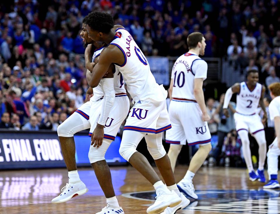 Kansas teammates Marcus Garrett (0) and Malik Newman celebrate after beating Duke in the championship game of the Midwest regional of the 2018 NCAA tournament.