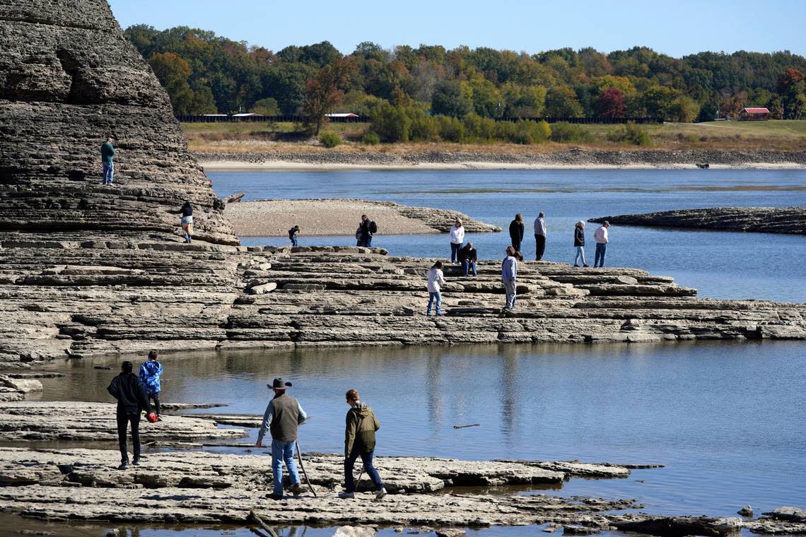 People walk to Tower Rock, an attraction normally surrounded by the Mississippi River and only accessible by boat, Wednesday, Oct. 19, 2022, in Perry County, Mo. Foot traffic to the rock formation has been made possible because of near record low water levels along the river.