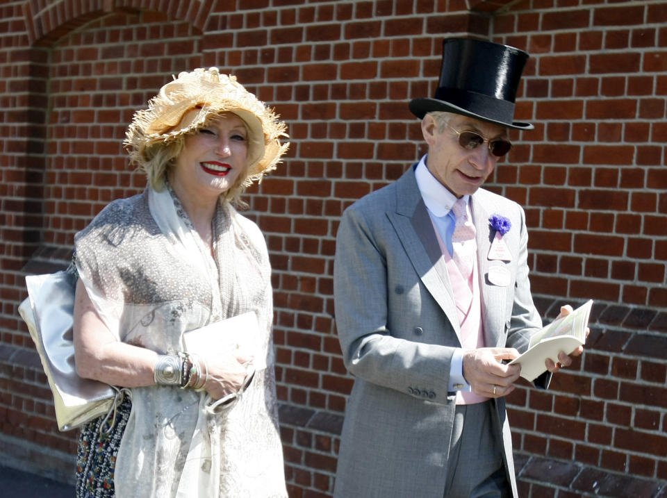 FILE - Charlie Watts, the drummer of the Rolling Stones, with his wife Shirley, arrive on the third day of the Royal Ascot horse racing meeting at Ascot, England, Thursday, June, 17, 2010. Shirley Ann Watts, a former art student and prominent breeder of Arabian horses who met drummer Charlie Watts well before he joined the Rolling Stones and with him formed one of rock's most enduring marriages, has died at age 84. "Shirley died peacefully on Friday 16th December in Devon after a short illness surrounded by her family," her family announced Monday, Dec. 19, 2022. (AP Photo/Alastair Grant, File)