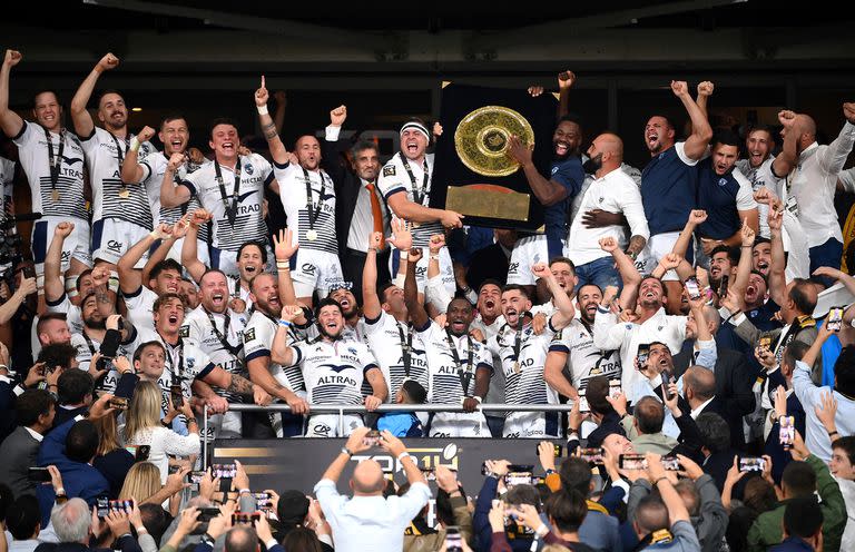 Altrad celebra al lado del capitán, Guilhem Guirado, y el resto del plantel con el peculiar trofeo Bouclier de Brennus; el propietario de Montpellier comparte tiempo con el plantel y se involucra continuamente con el equipo.