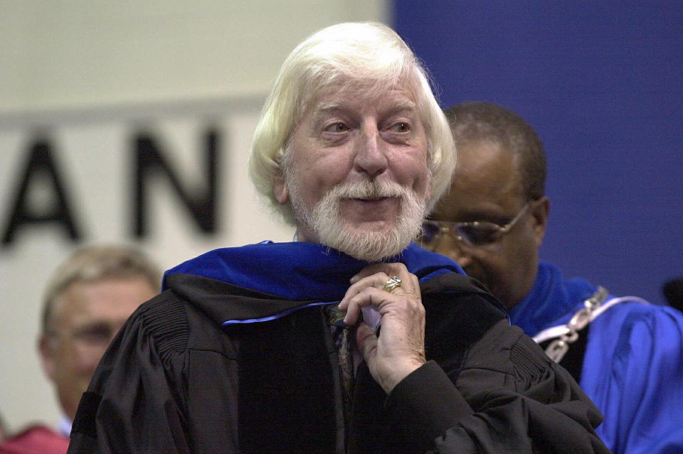 CORRECTS SPELLING OF FIRST NAME TO CAROLL, INSTEAD OF CARROL - FILE - In a May 21, 2000, file photo, Caroll Spinney, center, best known for his TV character Big Bird from "Sesame Street," receives an honorary doctor of Humane Letters degree from Eastern Connecticut State University President David G. Carter, right, during commencement in Willimantic, Conn. Spinney, who gave Big Bird his warmth and Oscar the Grouch his growl for nearly 50 years on “Sesame Street,” died Sunday, Dec. 8, 2019, at his home in Connecticut, according to the Sesame Workshop. He was 85. (AP Photo/Steve Miller, File)