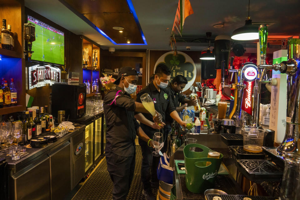 Baristas preparan bebidas en el "Irish Pub", uno de los bares que mostrarán los partidos del Mundial 2002 en pantallas en vivo en Qatar, el jueves 20 de octubre de 2022. (AP Foto/Nariman El-Mofty)