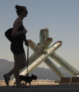 A woman walks past the Olympic Cauldron, one of the few signs left of the 2010 Olympic Winter Games held earlier this year, in Vancouver, British Columbia July 9, 2010. The games cost the British Columbia government $ 895.6 million ($925 million CAD) to stage and host, according to the latest figures released. REUTERS/Andy Clark