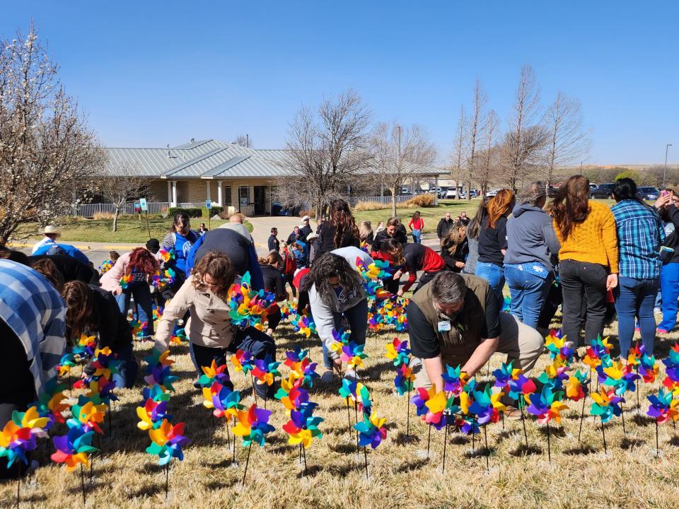 Friday morning, local organizations climbed the lawn in front of the Bridge Advocacy Center to plant brightly colored pinwheels, which will be spinning throughout the month of April in honor of every child who was interviewed by The Bridge staff in 2022.