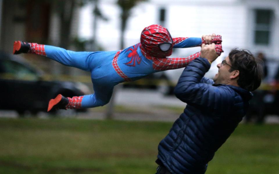 Jude Moquin swings out in a high flying spin in his Spiderman costume with help from his dad Cameron.  